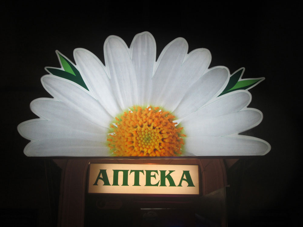 Фото светового короба для аптеки и световой фигуры цветка ромашки